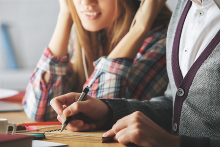 Close up of european guy and girl doing paperwork in modern office. Teamwork conceptの写真素材