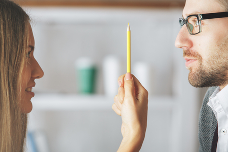 Portrait of attractive european male and female playing with supplies at workplace. Break conceptの写真素材