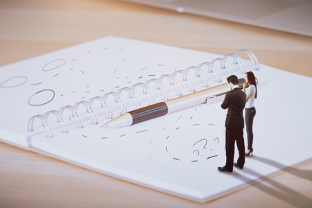 Tiny young man and woman standing on abstract spiral notepad with different drawn directions. Choice conceptの写真素材