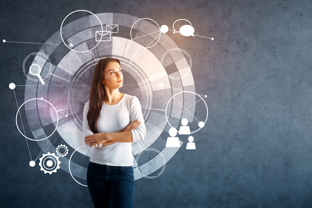Attractive young european woman standing on concrete background with digital business chart. Technology conceptの写真素材