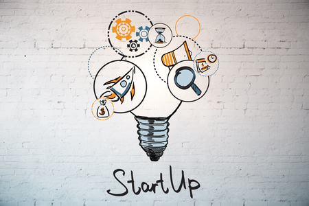 Brick wall with drawn lamp, space ship and other business icons. Entreprenurship ideasの写真素材