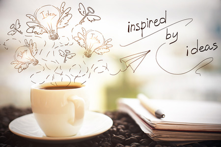 Close up of coffee cup, notepad with pen and creative sketch on blurry city background. Inspiration conceptの写真素材