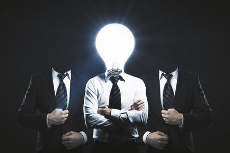Light bulb headed businessmen on dark background. Innovation conceptの写真素材