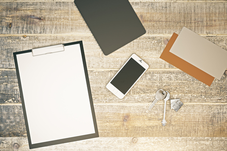 Top view of wooden desktop with empty clipboard, smartphone, metal keys and other items. Lifestyle concept. Mock up, 3D Renderingの写真素材