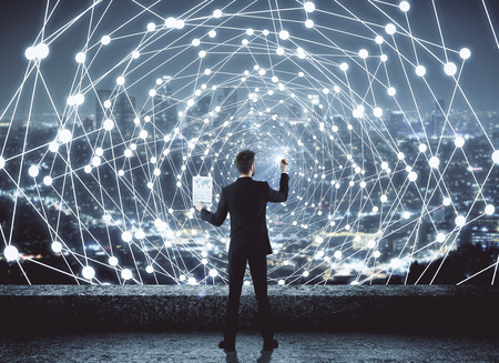 back view of young businessman drawing abstract polygonal digital mesh on night city background. Network and communication concept. 3D Renderingの写真素材