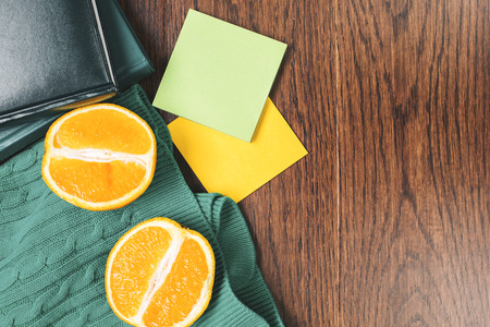 Top view of messy office desk with empty green colorful supplies and orange halves. Mock upの写真素材
