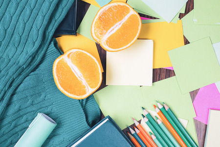 Top view of messy office desktop with empty green colorful stationery items and orange halves. Mock upの写真素材