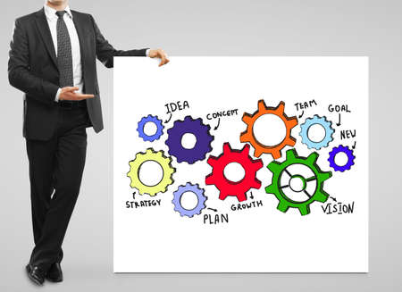 Businessman showing banner with drawn colorful cogs. Business conceptの写真素材