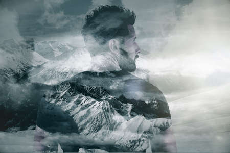 Back view of young european man on creative snowy winter mountain landscape background. Freedom and leadership concept. Double exposureの写真素材