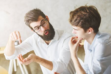 Portrait of two handsome businessmen communicating in modern office. Teamwork and partnership conceptの写真素材