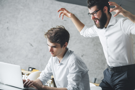 Crazy frustrated wite businessmen colleagues in modern office interiorの写真素材