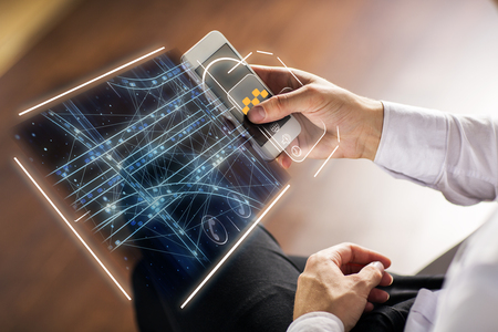 Side view of businessman hands using smartphone with abstract digital hologram for tracking taxi car on map. App, application and future concept. Blurry wooden floor backgroundの写真素材
