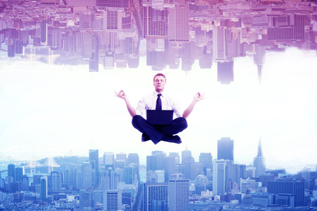 Meditating businessman on abstract upside down rainbow city background. Relaxation  conceptの写真素材