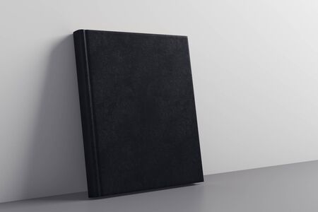Empty closed black hardcover notepad leaning on concrete wall. Advertising concept. Mock up, 3D Renderingの写真素材