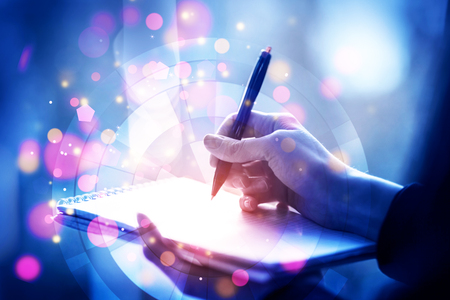 Close up of female hands writing in notepad with abstract digital pattern. Future concept. Double exposureの写真素材