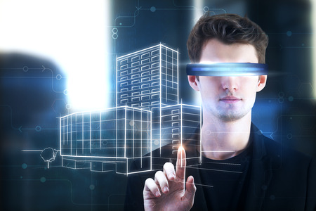 Portrait of handsome young european businessman with virtual reality glasses pointing at city...
