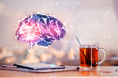Close up of office workplace with polygonal brain hologram, tea cup, tablet and city view. Innovation and medicine concept. Double exposure の写真素材