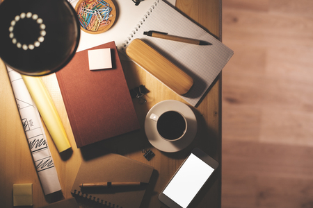 Top view of night office desktop with empty smartphone, coffee cup and stationery tools and items. Mock upの写真素材