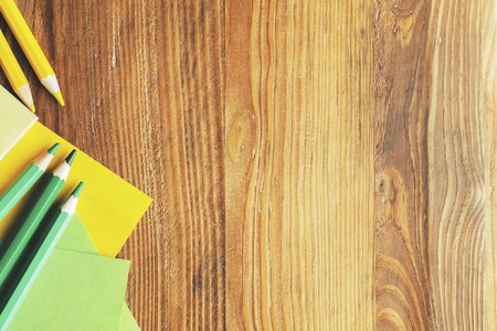 Top view of textured wooden desk top with stationery and other items. Education and close up concept, Mock up 
の写真素材