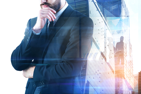 Thoughtful young businessman on abstract city background. Career and employment concept. Double exposure の写真素材