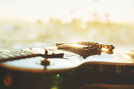 Close up of guitar on blurry background with sunlight. Leisure and music concept 
