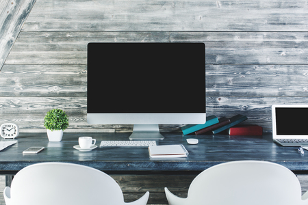 Close up of modern table with blank computer monitor, stationery items and other objects. Design and advertisement concept. Mock up の写真素材