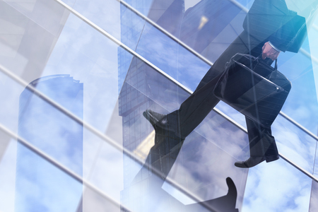 Businessman with briefcase walking on abstract city background. Success concept. Double exposure の写真素材