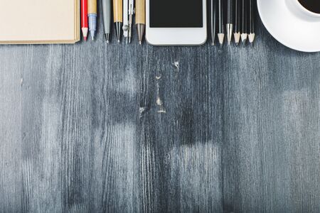 Top view of office desktop with empty smartphone device, supplies and other items. Mock up