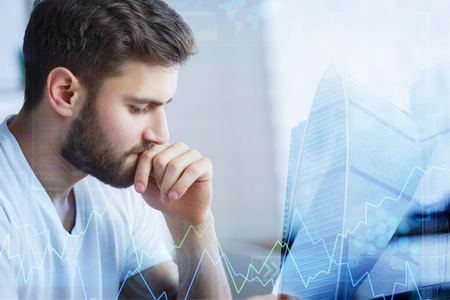 Investment and growth concept. Thoughtful young businessman on abstract city background with forex chart. Double exposure の写真素材