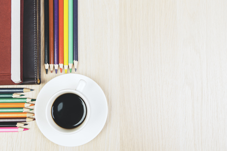 Top view of wooden office desktop with coffee cup, supplies and copy space. Close up and Mock up の写真素材