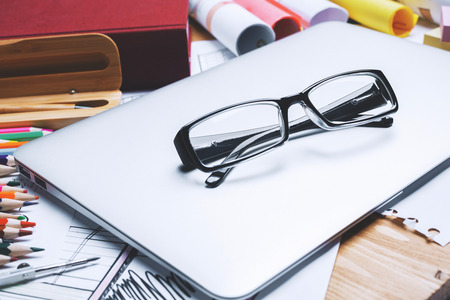 Close up of glasses on office desktop with other items. Eyesight and work conceptの写真素材