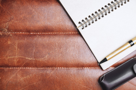 Top view of brown leather desktop with supplies, other items and copy space. Mock up