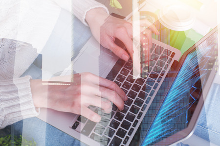Female hands using laptop with business chart at modern office workplace. Accounting and sales concept. Double exposure の写真素材