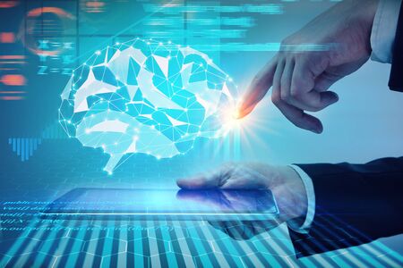 Side view of businessman hand holding and pointing at tablet with abstract polygobal brain hologram....