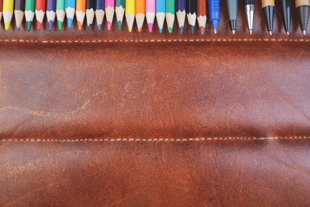 Top view of brown leather table top with supplies, other items and copy space. Design and occupation concept. Mock up の写真素材