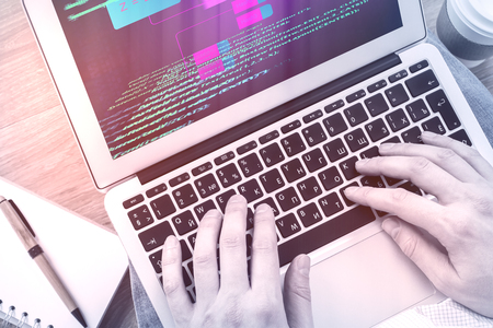 Close up of hands typing html code on laptop keyboard. Computing and software concept の写真素材
