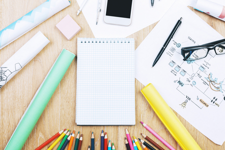 Top view and close up of modern light wooden office tabletop with smartphone, supplies and other items. Mock upの写真素材