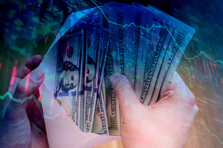 Male hand holding envelope with dollar bills on abstract forex background. Bribery and investment concept. Double exposure の写真素材