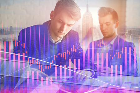 Attractive european businessman working on project together in modern office with abstract forex...