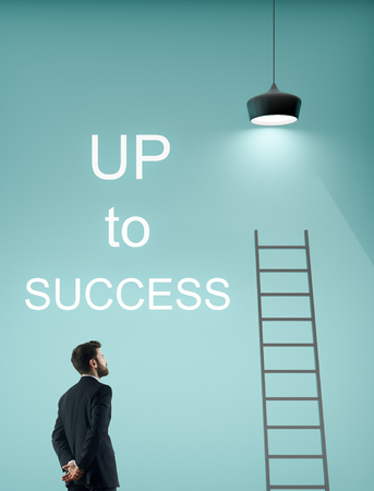 Side view of thoughtful young businessman standing on blue background with ladder, lamp and text. Success and promotion conceptの写真素材