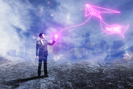 Businessman with digital kyte on abstract outdoor background. Dreams concept. Double exposureの写真素材