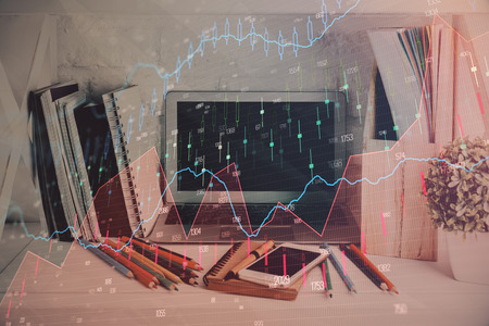 Double exposure of stock market chart and office desktop on background. financial strategy concept.の写真素材