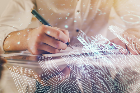 Abstract holographic city on mans hand writing notes background. Double exposure.の写真素材