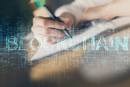 Cryptocurrency hologram, bitcoin, ico theme over hands taking notes background. Concept of blockchain. Multi exposureの写真素材