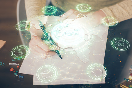 Social network theme hologram over hands taking notes background. Concept of global international...