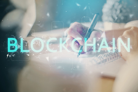 Cryptocurrency hologram, bitcoin, ico theme over hands taking notes background. Concept of...
