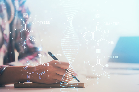 DNA theme hologram over womans hands writing background. Concept of education. Double exposureの写真素材