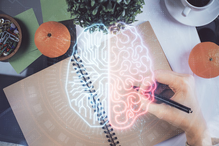 Double exposure of writing hand on background with brain hologram. Concept of learning.の写真素材