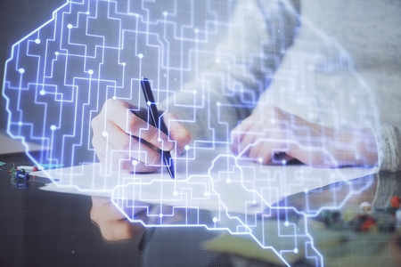 Double exposure of womans writing hand on  with brain hud. Concept of learning.の写真素材