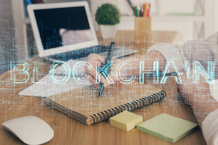 Cryptocurrency hologram, bitcoin, ico theme over hands taking notesの写真素材